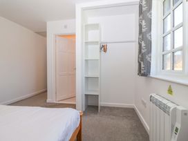 A bedroom with a wardrobe and door at Bracken Cottage St Tudy