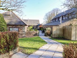 A courtyard with buildings and pathway at Bracken Cottage St Tudy