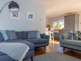 A living room with sofas and kitchen area at 38 Venn Park Stoke Fleming