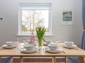 A dining room table set for a meal with flowers at 38 Venn Park Stoke Fleming