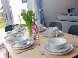 A dining table set with bowls, plates, glasses, and a vase of tulips at 38 Venn Park in Stoke Fleming