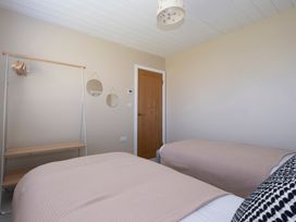 A bedroom with two beds and a wardrobe at 38 Venn Park in Stoke Fleming