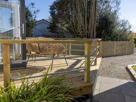 An outdoor area with a decking, rattan chair and plants at 38 Venn Park Stoke Fleming