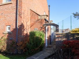 An outdoor view of a brick house entrance with a gate at Pond Farm View in Hinderwell