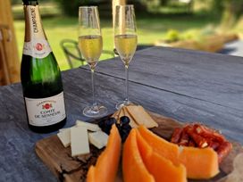 A table with champagne glasses and cheese platter at Dryslwyn Cottage in Llandeilo
