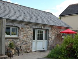 A stone cottage entrance with a table and chairs at Dryslwyn Cottage in Llandeilo
