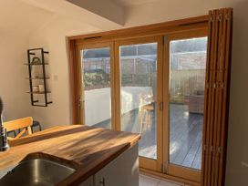 A kitchen with a sink and folding doors at Owl's Rest in Weymouth