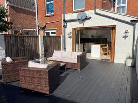 An outdoor seating area with a sofa and table at Owl's Rest in Weymouth