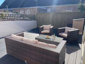 An outdoor patio with seating and a coffee table at Owl's Rest in Weymouth