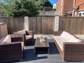 A garden with seating and a coffee table at Owl's Rest in Weymouth