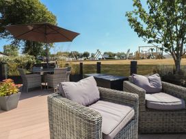 An outdoor patio with seating and a playground in the background at 97 Crugan Llanbedrog