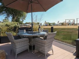 An outdoor area with a table and chairs under an umbrella at 97 Crugan Llanbedrog