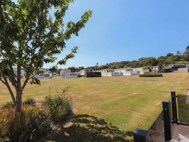 An outdoor view of holiday homes and grassy area at 97 Crugan Llanbedrog