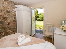A bedroom with a bed and a door leading outside at Cobwebs Cold Inn near Saundersfoot