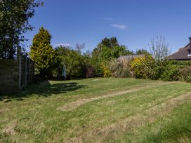 A garden with grass and trees at Cobwebs Cold Inn near Saundersfoot