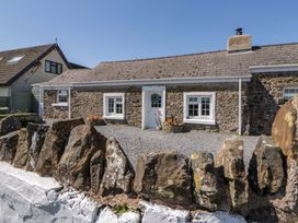 A house with a stone exterior and gravel area at Cobwebs Cold Inn near Saundersfoot
