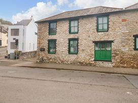 A stone building with green window frames next to a white modern building with a traffic light at 1 Greenswood Court in Brixham