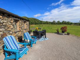 An outdoor seating area with chairs and a table at The Garden Suite at Fiddler Hall Barn Newby Bridge