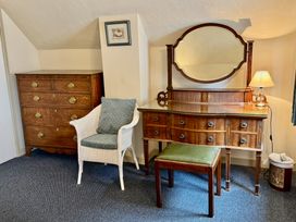 A bedroom with a dressing table and a chest of drawers at Cajun Cottage in West Lulworth
