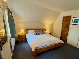 A bedroom with a bed and bedside tables at Cajun Cottage in West Lulworth