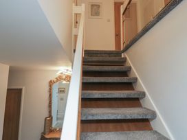 A staircase with a mirror and doors at Eildon Lodge in Gosforth