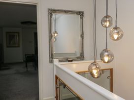 A hallway with a mirror and light fixture at Eildon Lodge in Gosforth