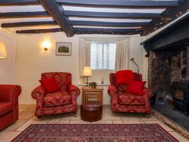 A living room with armchairs and a coffee table at Fox Hat Cottage in Chagford