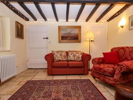 A sitting room with a sofa and an armchair at Fox Hat Cottage in Chagford