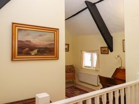 A sitting room with a painting and window at Fox Hat Cottage in Chagford