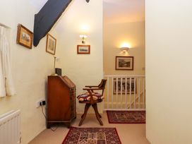 A hallway with a desk and chair at Fox Hat Cottage in Chagford