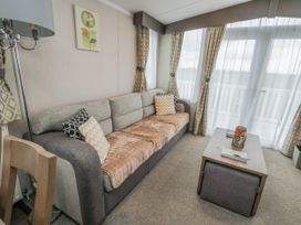 A living room with a sofa and coffee table at Trewan Chalet Bryngwran near Rhosneigr