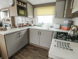 A kitchen with sink and appliances at Trewan Chalet in Bryngwran near Rhosneigr
