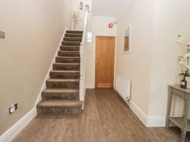 A hallway with a staircase and console table at Chestnuts Cottage in Windermere