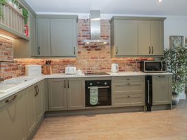 A kitchen with cabinets, sink, and appliances at Chestnuts Cottage in Windermere