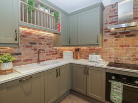 A kitchen with cabinets and a sink at Chestnuts Cottage in Windermere