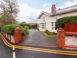 A house with a driveway and hedges at Bryn Offa cottage in Holywell