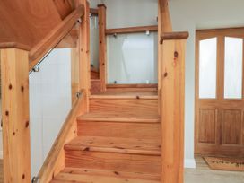 A wooden staircase with glass panels and a wooden door with frosted glass panels at The Old Haberdashery in Swanage