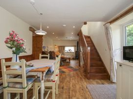 A living room with a dining area and staircase at Buzzards Breg Builth Wells