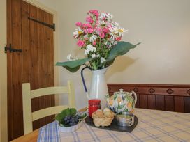 A kitchen table with flowers in a vase at Buzzards Breg in Builth Wells
