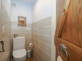 A bathroom with a toilet and a mirror at Buzzards Breg in Builth Wells
