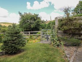 A garden with a gate and trees at Buzzards Breg in Builth Wells