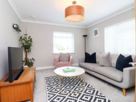 A living room with a sofa and coffee table at 3 Tai Newydd Llanfaelog near Rhosneigr
