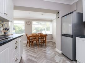 A kitchen with a table and chairs at 3 Tai Newydd Llanfaelog near Rhosneigr