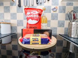 A kitchen countertop with snacks including crisps and apple juice at 3 Tai Newydd Llanfaelog near Rhosneigr