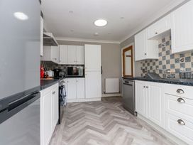 A kitchen with appliances and cabinets at 3 Tai Newydd Llanfaelog near Rhosneigr