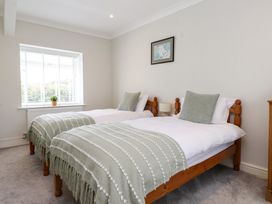 A bedroom with twin beds and a window at 3 Tai Newydd in Llanfaelog near Rhosneigr