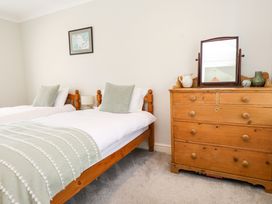 A bedroom with two beds and a dresser at 3 Tai Newydd Llanfaelog near Rhosneigr