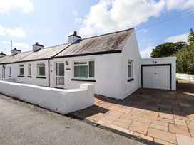 A house with a garage and patio area at 3 Tai Newydd Llanfaelog near Rhosneigr
