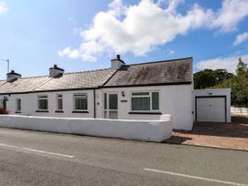 A bungalow with a garage and wall at 3 Tai Newydd Llanfaelog near Rhosneigr
