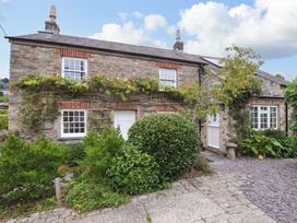 A stone cottage with plants in the garden at Island House in Golant near Tywardreath